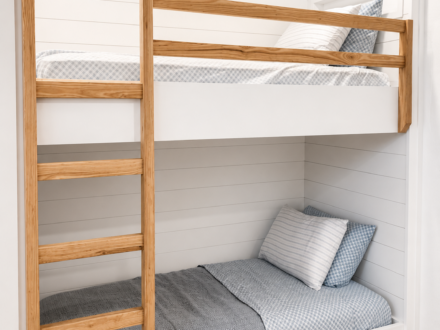 Custom built-in bunk beds featuring white shiplap walls, natural wood ladder and guardrail, integrated storage drawers, and a clean coastal-inspired design.