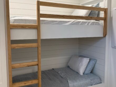 Custom bunkbeds with shiplap accent walls and storage