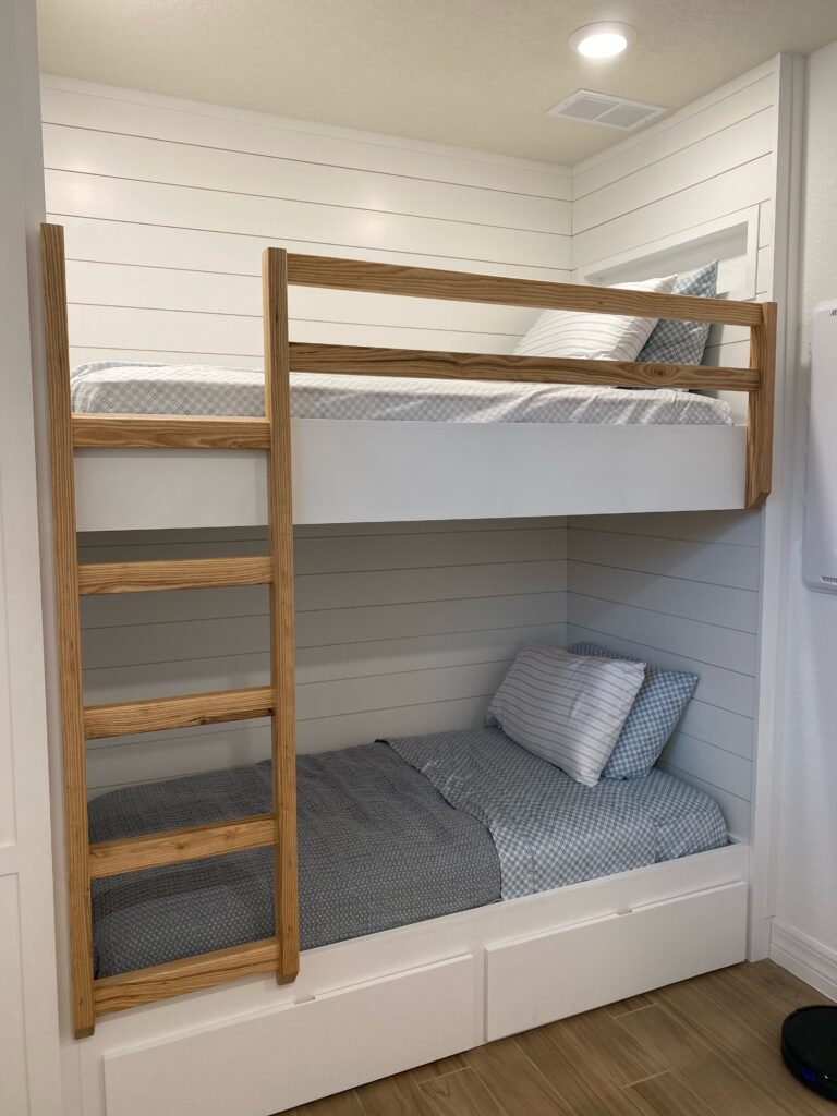 Custom bunkbeds with shiplap accent walls and storage