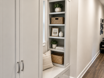 Custom mudroom built-in featuring a tall storage cabinet, bench seating, open shelving, and integrated storage designed for organization in a hallway entry space.
