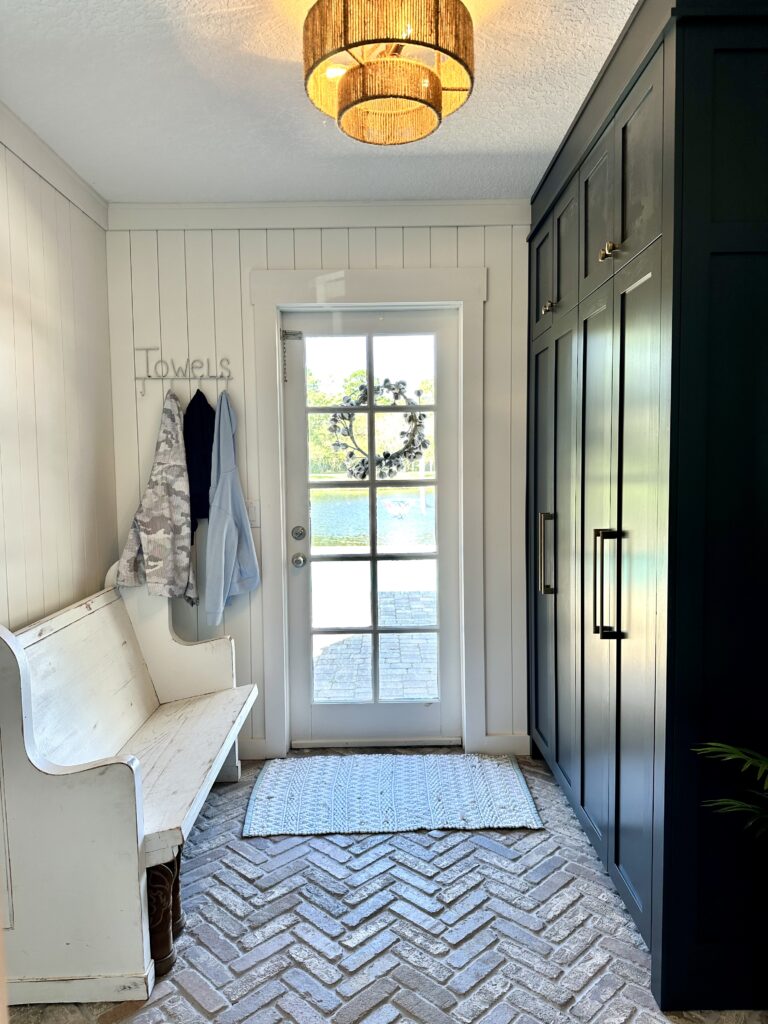 Mudroom with cabinets and herringbone brick flooring